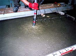 Vibrator inserted into concrete during placement and consolidation
