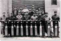 Monochrome photograph of multiple people holding pneumatic vibrators for dam construction